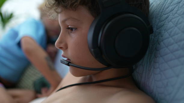 istock Child connected online wearing headphone with microphone set playing game 1363528309