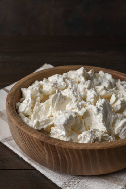 istock Cottage curd cheese in a bowl on old wooden table. 1363529183