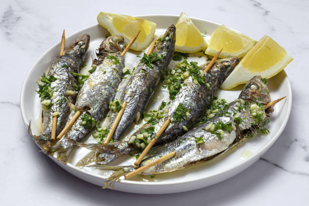 Homemade Grilled Sardines with Garlic, Olive Oil, Fresh Parsley, and Lemon Homemade Grilled sardines with garlic, olive oil, fresh parsley and lemon.Healthy food concept sardine stock pictures, royalty-free photos & images