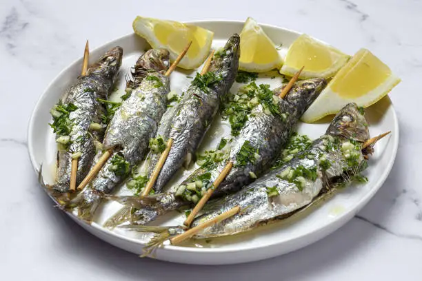 Homemade Grilled sardines with garlic, olive oil, fresh parsley and lemon.Healthy food concept
