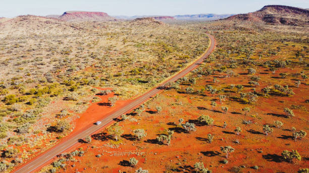 Aerial view of camper van driving along the red road Aerial view of camper van driving along the red scenery of Karijini, WA outback stock pictures, royalty-free photos & images