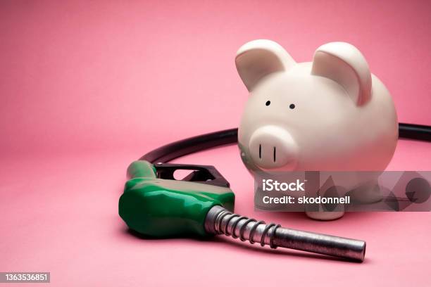 Concept Photo Of A White Large Piggy Bank On Pink Background With Gas Nozzle Stock Photo - Download Image Now