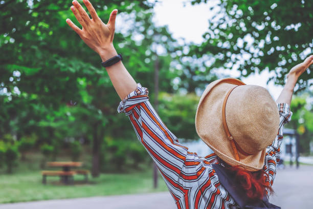 istock Woman raising her hand towards the sky 1363543444