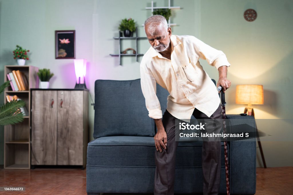 Old Man Trying Get Up From Sofa With Support Of Cane Or Walking