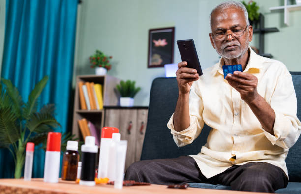 Senior man checking about availability, purchasing or ordering online medicines on mobile phone from home - concept of E-Pharmacy Senior man checking about availability, purchasing or ordering online medicines on mobile phone from home - concept of E-Pharmacy and searching about medications. buy tablets online stock pictures, royalty-free photos & images