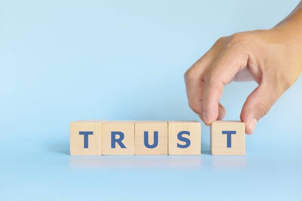 istock Build trust concept. Hand stacking wooden blocks with word trust. 1363549166