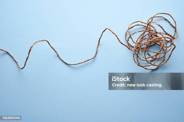 Spool And Tangled Blue Thread Isolated On Blue Background Stock Photo - Download Image Now
