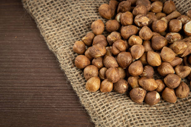 istock Heap of peeled hazelnuts on wooden table 1363558069