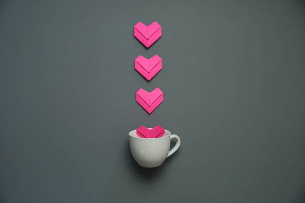pink heart paper art on a coffee cup.