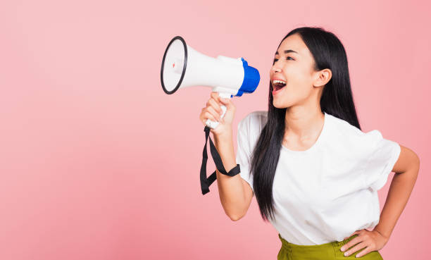 woman teen confident smiling face holding making announcement message shouting screaming in megaphone stock photo