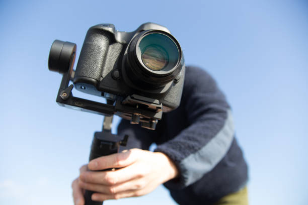 istock man filming with camera and gimbal against blue sky background 1363564525