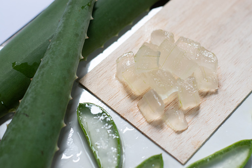 Aloe vera gel on wooden plate and white background, skin cosmetic plant, Topical antibiotic treatment.