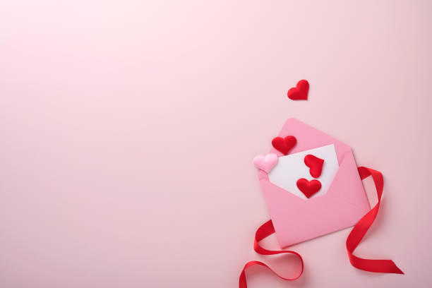открытка на день святого валентина. розовый пустой конверт с пустым макетом белой ноты внутри, макаронное печенье макарун и кофейная чашка  - romance gift rose valentines day стоковые фото и изображения