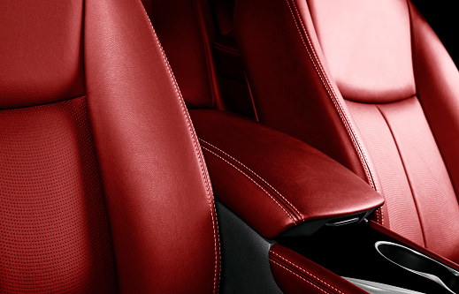 Interior de cuero rojo de coche de lujo. Parte de detalles de cuero de la silla de auto con costuras. Cómodos asientos de cuero rojo perforado. Cuero rojo perforado. Coche en el interior photo