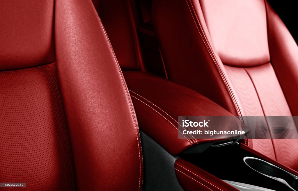 Luxury car red leather interior. Part of leather car seat details with stitching. Comfortable perforated red leather seats. Red perforated leather. Car inside Car Interior Stock Photo