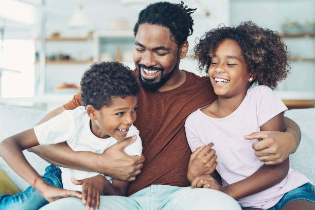 Father holding his children Happy African ethnicity father playing with his daughter and son at home one parent stock pictures, royalty-free photos & images