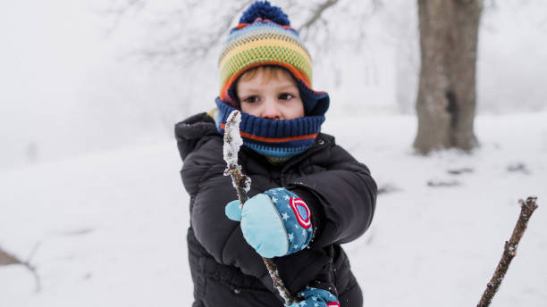 istock Child playing with snow in winter 1363578186