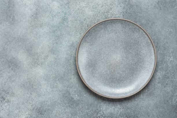 istock Empty gray plate on gray rustic concrete background. Top view, flat lay. 1363579618