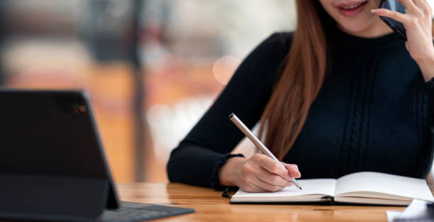 istock Woman using smartphone, writing note and working on portable tablet, businesswoman or student girl online learning at cafe. 1363579864