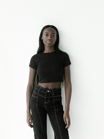 Portrait of beautiful young african girl wearing black crop top and jeans pants. Looks fresh and lovely Fashion model studio portrait on white background Korean fashion style Fitness Healthcare concept
