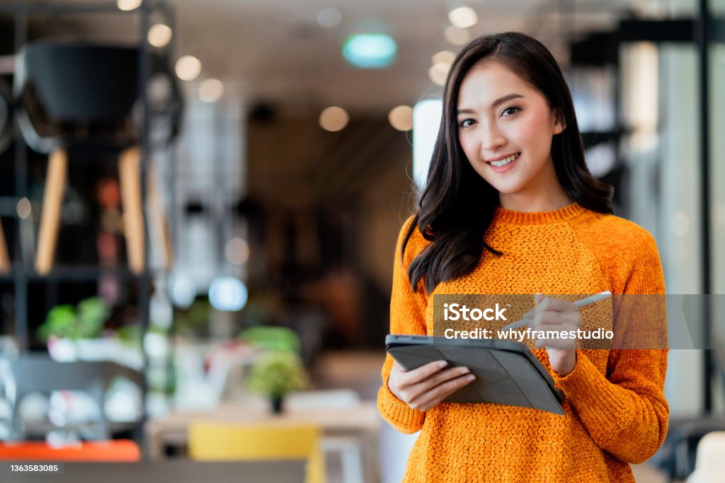 smart confidence asian female startup entrepreneur small business owner businesswoman wear smart casual cloth smile hand use tablet woking inventory checking in showroom office daytime background Asian and Indian Ethnicities Stock Photo