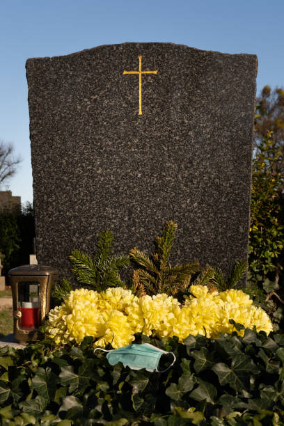 istock Grave with protective face mask, covid death. 1363585431