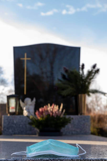 istock Grave with protective face mask, covid death. 1363585444