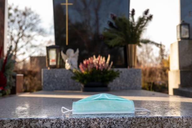 istock Disposable surgical face mask on a grave. 1363585448