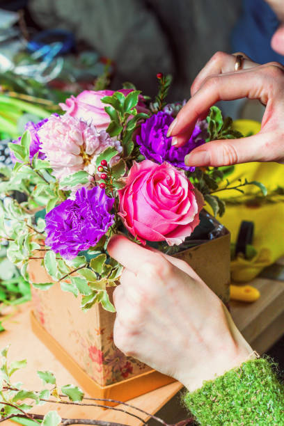 istock Florist at work assembling the bouquet of tulips in a hat box 1363586308