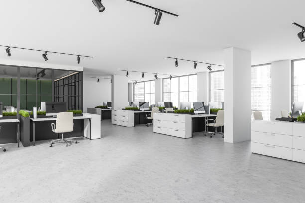 istock White open space interior with armchairs and pc on concrete floor, windows 1363586563