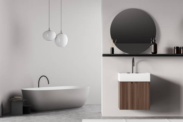 istock White bathroom interior with sink and mirror, bathtub and lamp 1363586622