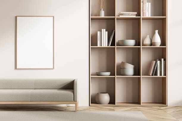 istock Light waiting room interior with sofa on carpet, bookshelf and mockup poster 1363586688