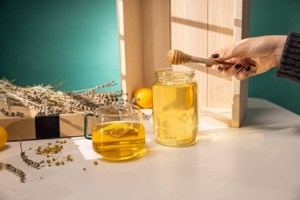 istock Honey dripping from wooden honey dipper 1363588217