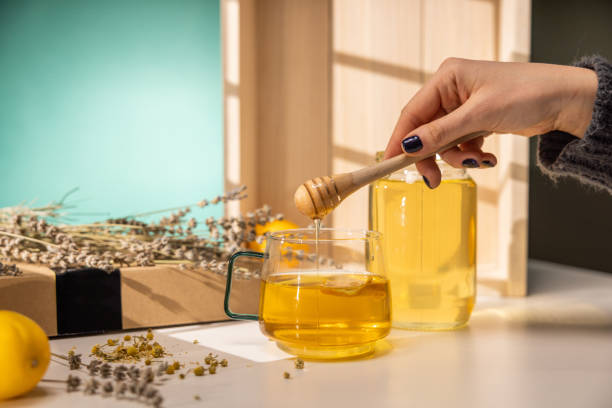 istock Honey dripping from wooden honey spoon 1363588256