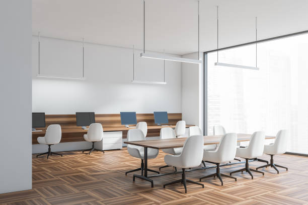 istock Light business room interior with seats, table and pc, window with city view 1363588771