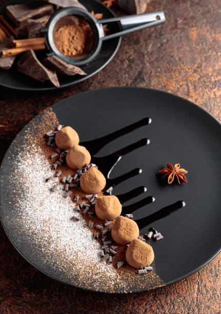 istock Chocolate truffles on a black plate with chocolate sauce. 1363592843