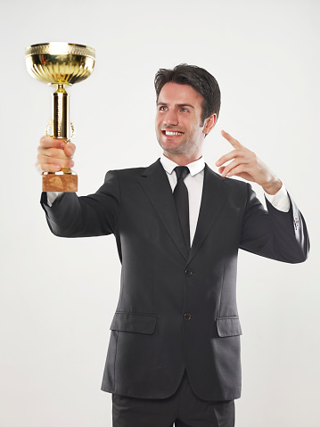 Businessman holding a trophy.