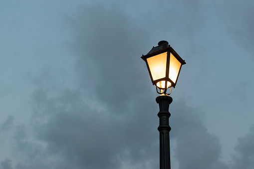 Silhouette of a street lamp in the cloudy evening