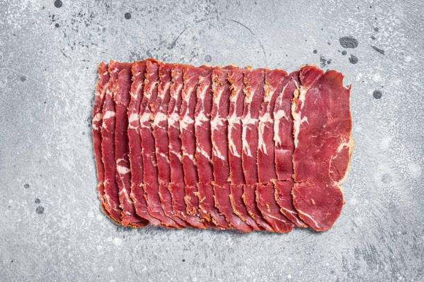 Turkish bacon Pastrami beef meat. Gray background. Top view Turkish bacon Pastrami beef meat. Gray background. Top view. pastrami stock pictures, royalty-free photos & images