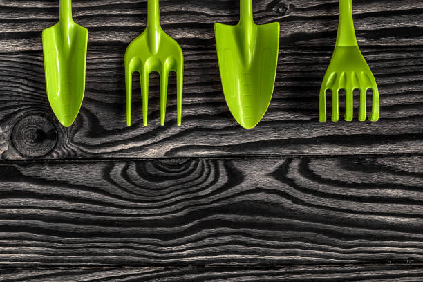 istock Gardening tools concept. Spade, rake and fork on wooden background with space for text flat lay top view. 1363597398