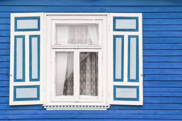 istock Blue paint wooden rustic window in small cottage house. 1363597533