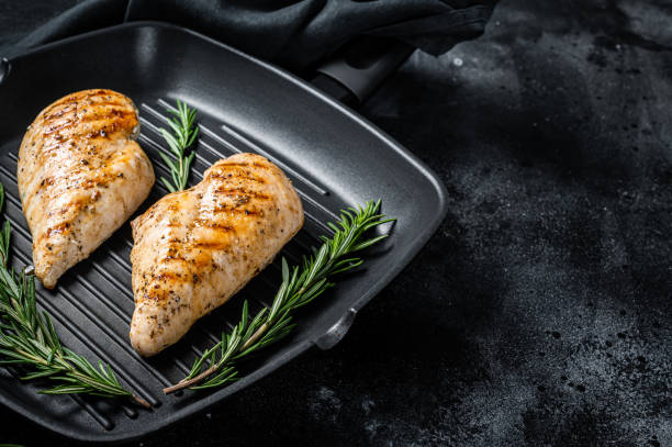 istock Grilled healthy chicken breasts cooked on a grill pan. Black background. Top view. Copy space 1363597660