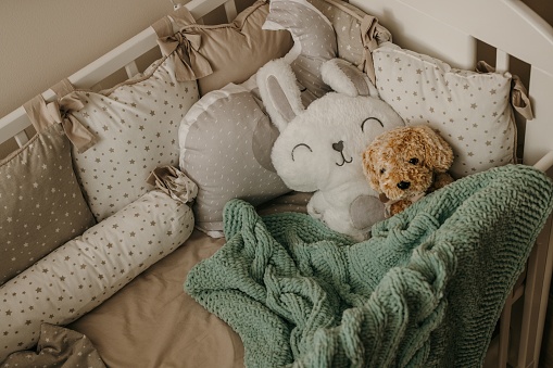 Empty baby crib with stuffed toys inside