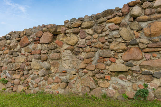 istock An old medieval stone wall against blue sky as background 1363599233