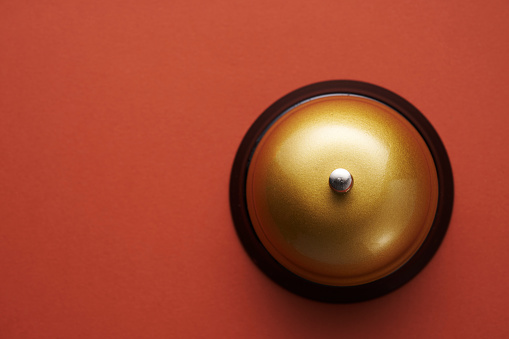 gold colored service bell on red background