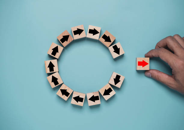 Disruption and technology transformation concept , Hand move out red arrow on wooden block cube move out from circle black arrow on blue background.