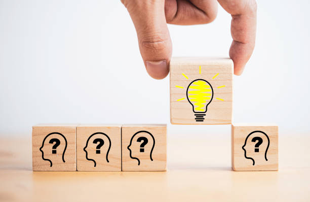 istock Hand holding lightbulb drawing which print screen on wooden cube block among human and question mark for creative thinking idea and problem solving concept. 1363599452