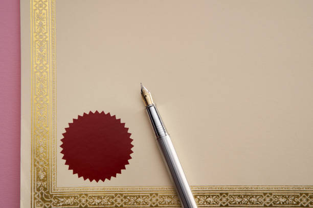 istock blank golden boarder certificate and fountain pen  on pink background 1363600510