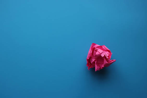 istock Pink paper and paper ball on blue background 1363602643