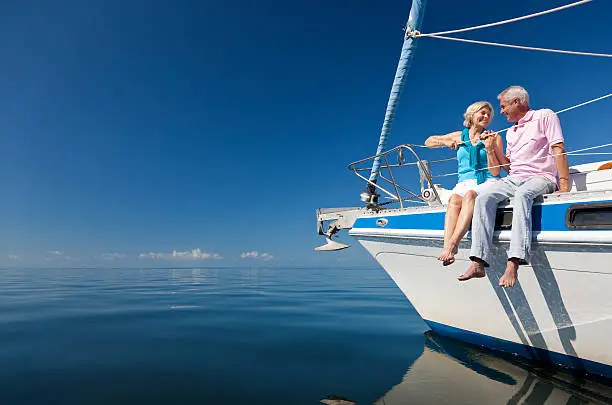 Photo of Happy Senior Couple on the Bow of a Sail Boat